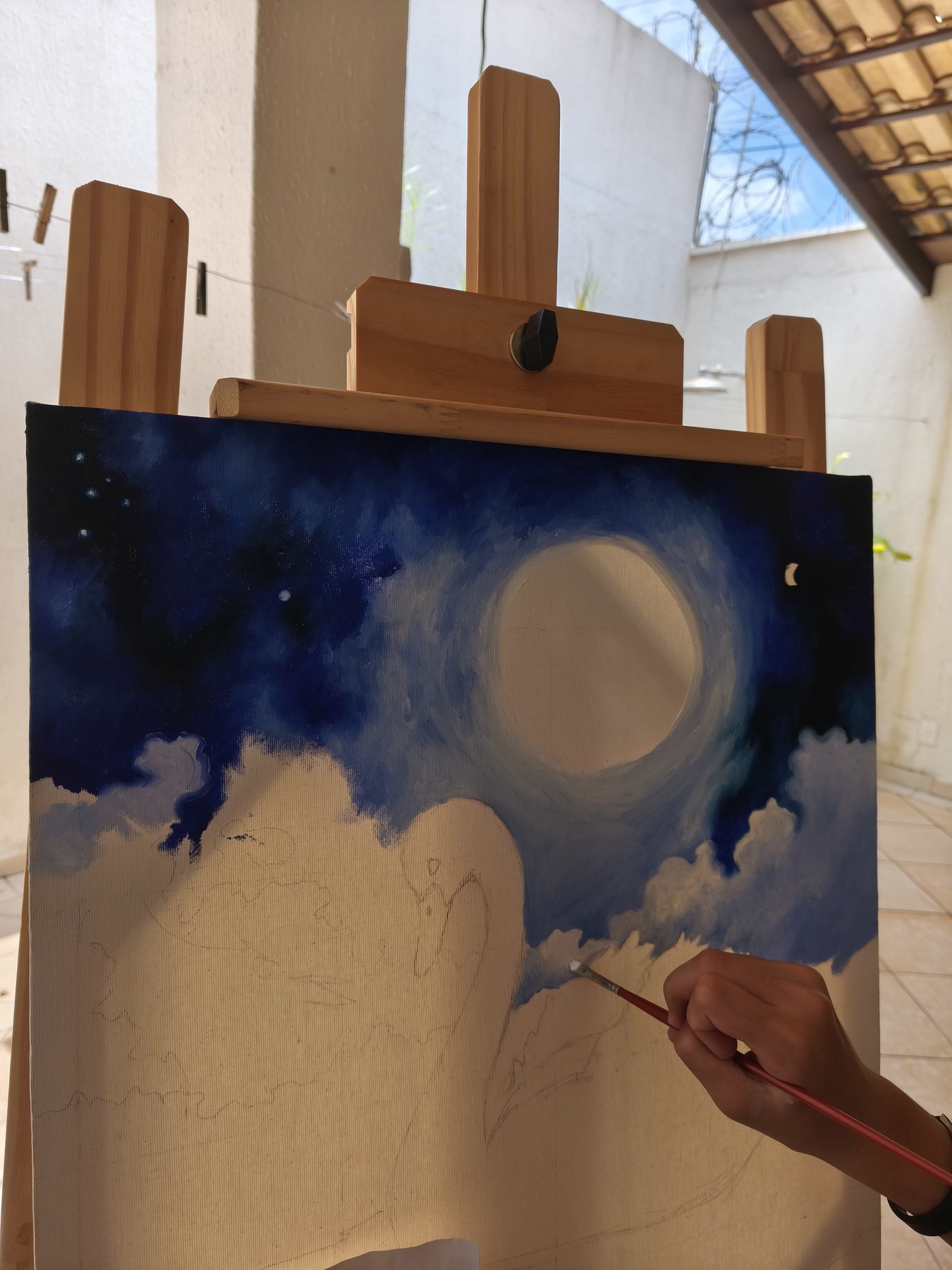 Tela no início da pintura, com o fundo escuro e o contorno da lua