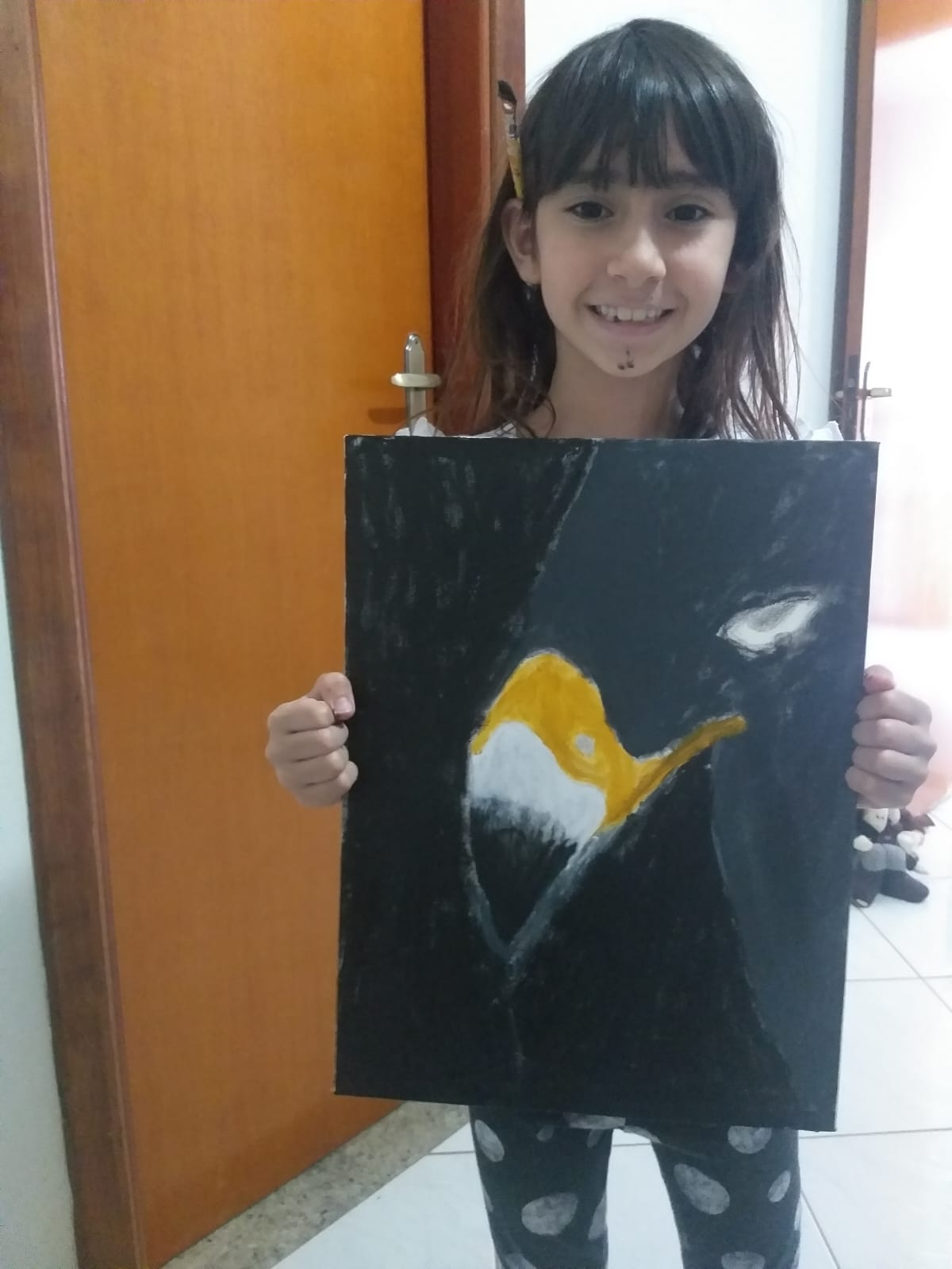 Helena segurando a pintura da águia finalizada